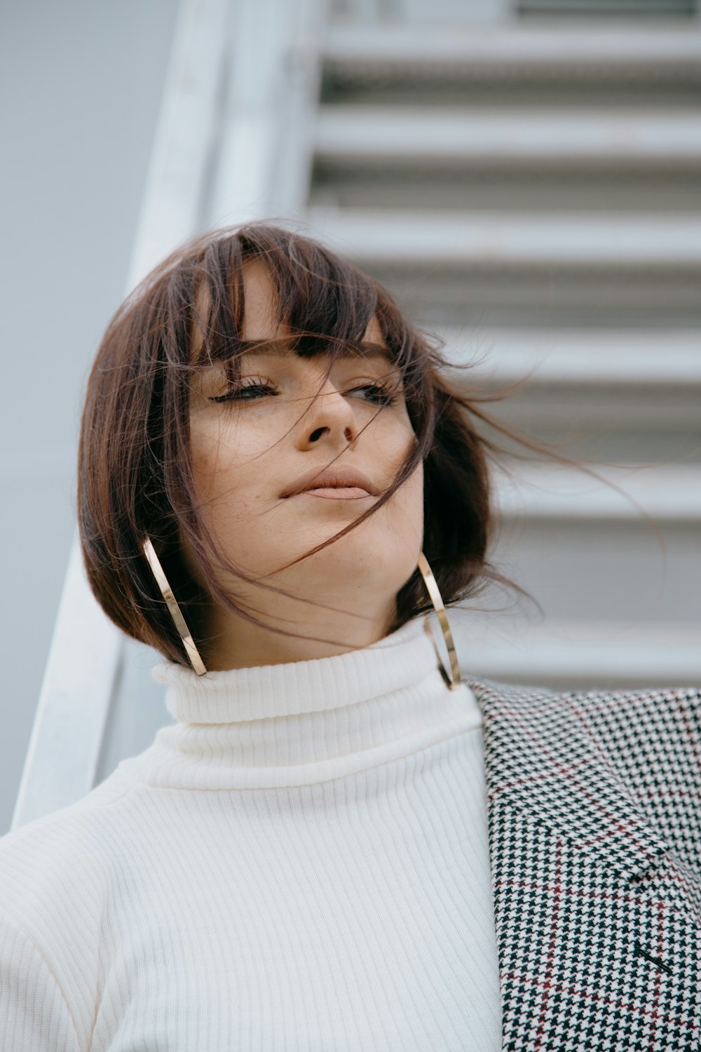 woman in white turtleneck sweater wearing white earbuds