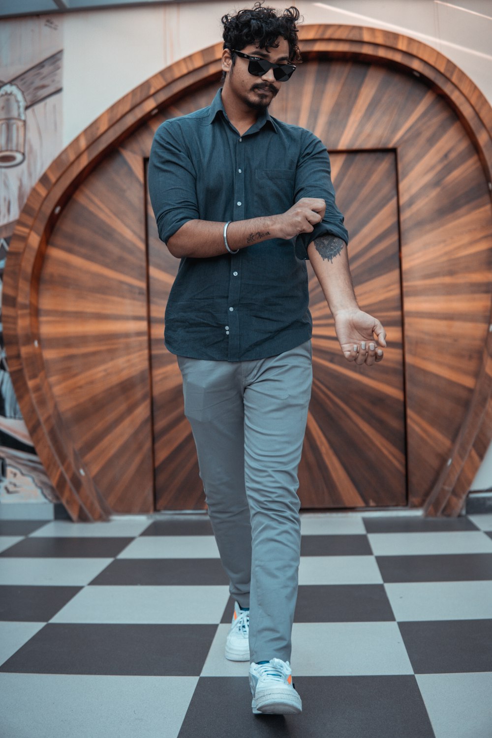 man in black dress shirt and gray pants standing on brown wooden floor  photo – Free Grey Image on Unsplash