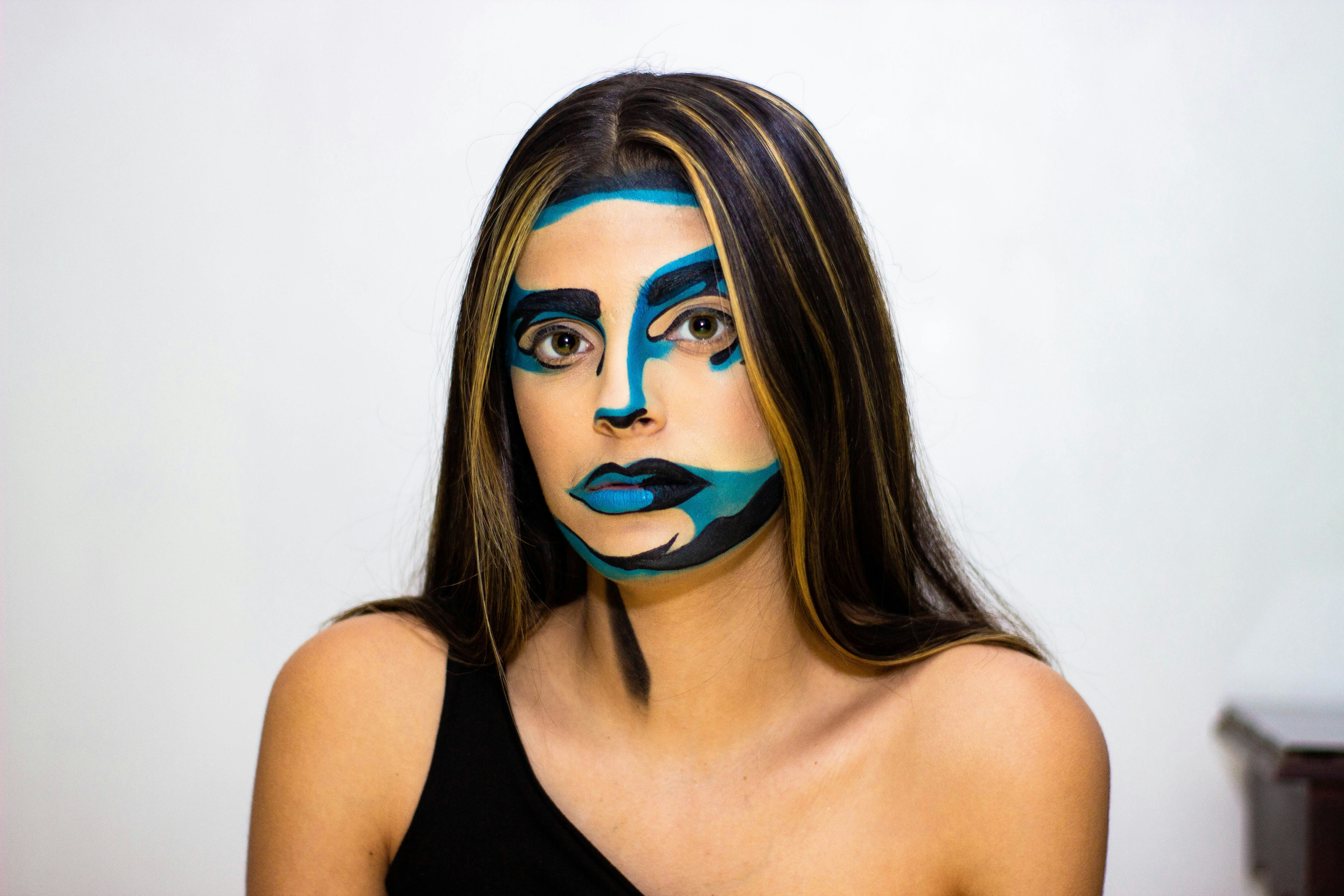 woman in black tank top with blue eye shadow