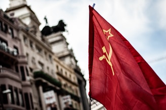 A stark illustration of a crumbling American flag overshadowed by symbols representing socialism, globalism, and political unrest.