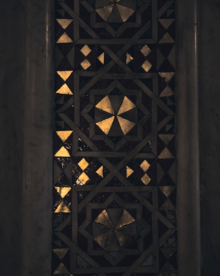 Elegant mosaic artwork featuring intricate patterns in desert-inspired beige and gold hues.