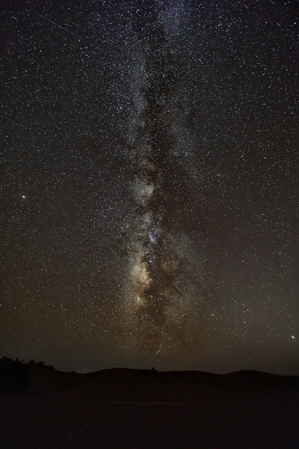 silhouette of mountain under starry night