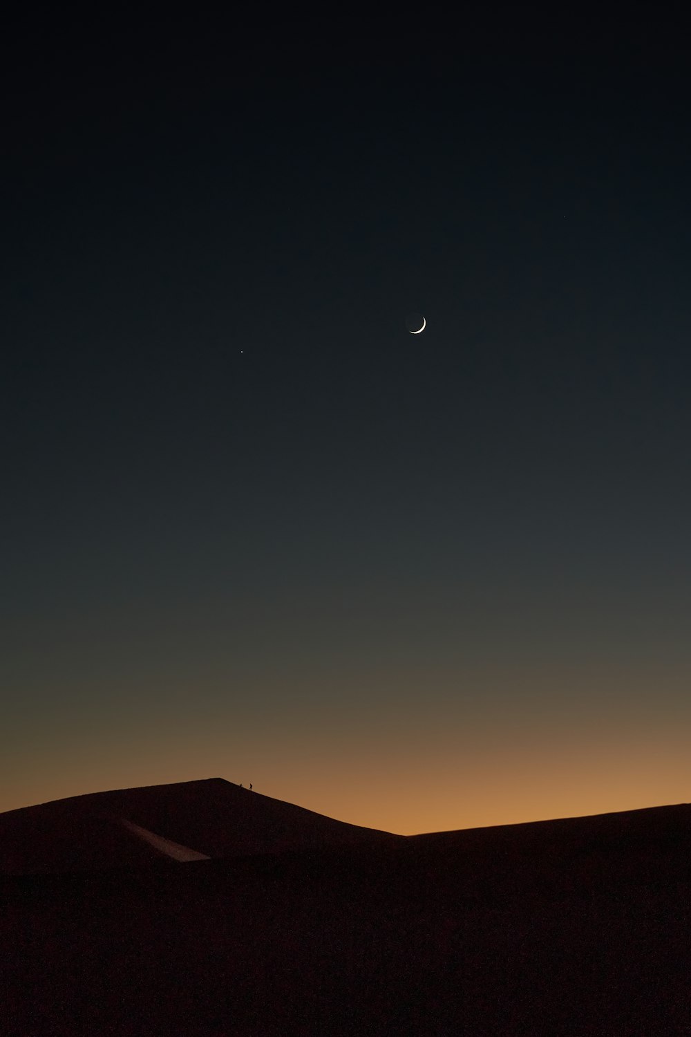 silhouette of mountain under blue sky during night time