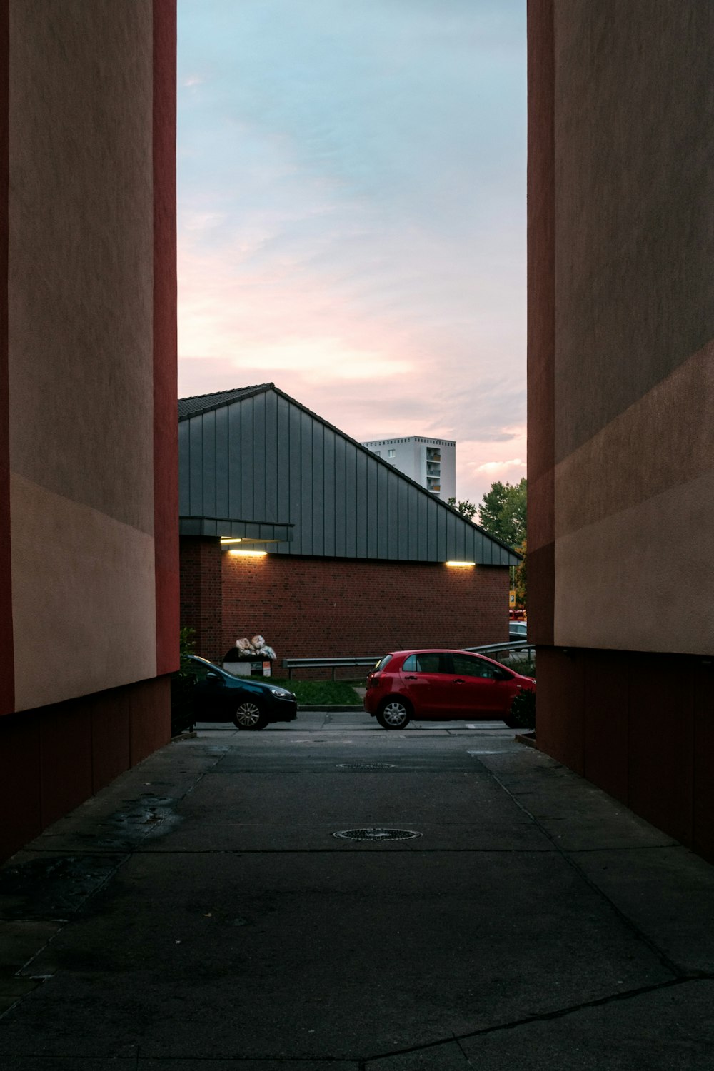 red car parked beside black car during sunset