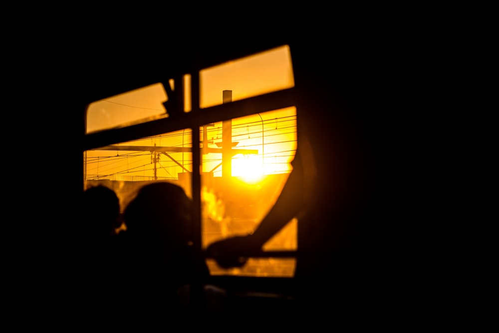 silhouette di persone sedute sulla sedia durante il tramonto