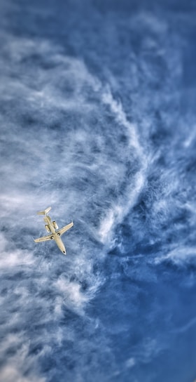A vibrant airplane flying above a clear blue sky.
