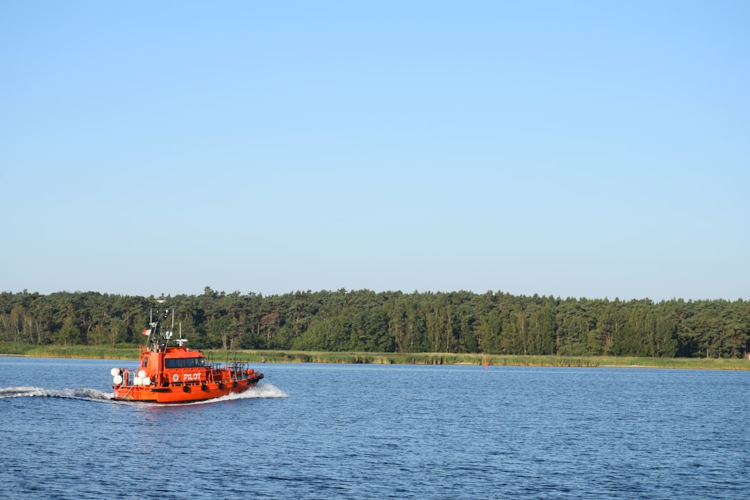 red boat on body of water during daytime