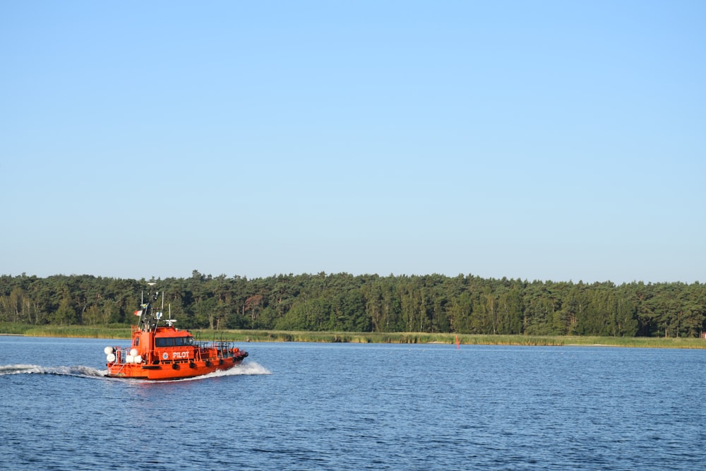 red boat on body of water during daytime