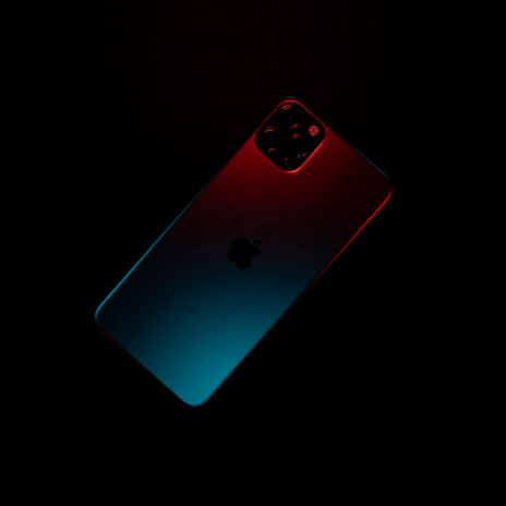 A sleek smartphone glowing with vibrant colors against a dark background, highlighting its premium design.
