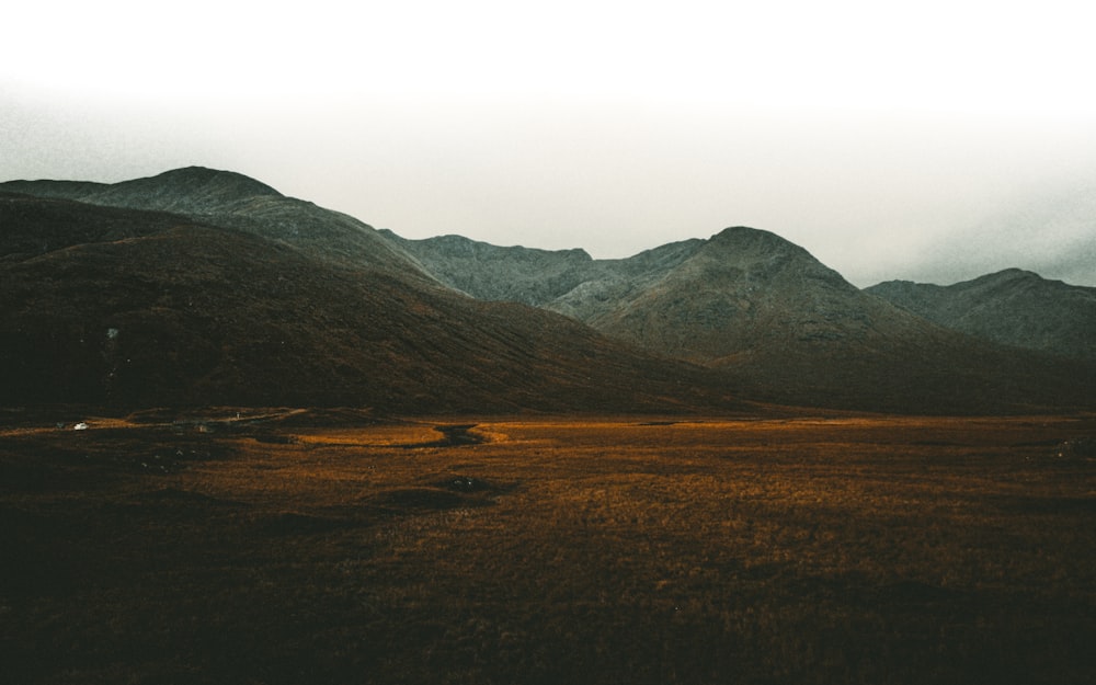 green grass field near mountain during daytime