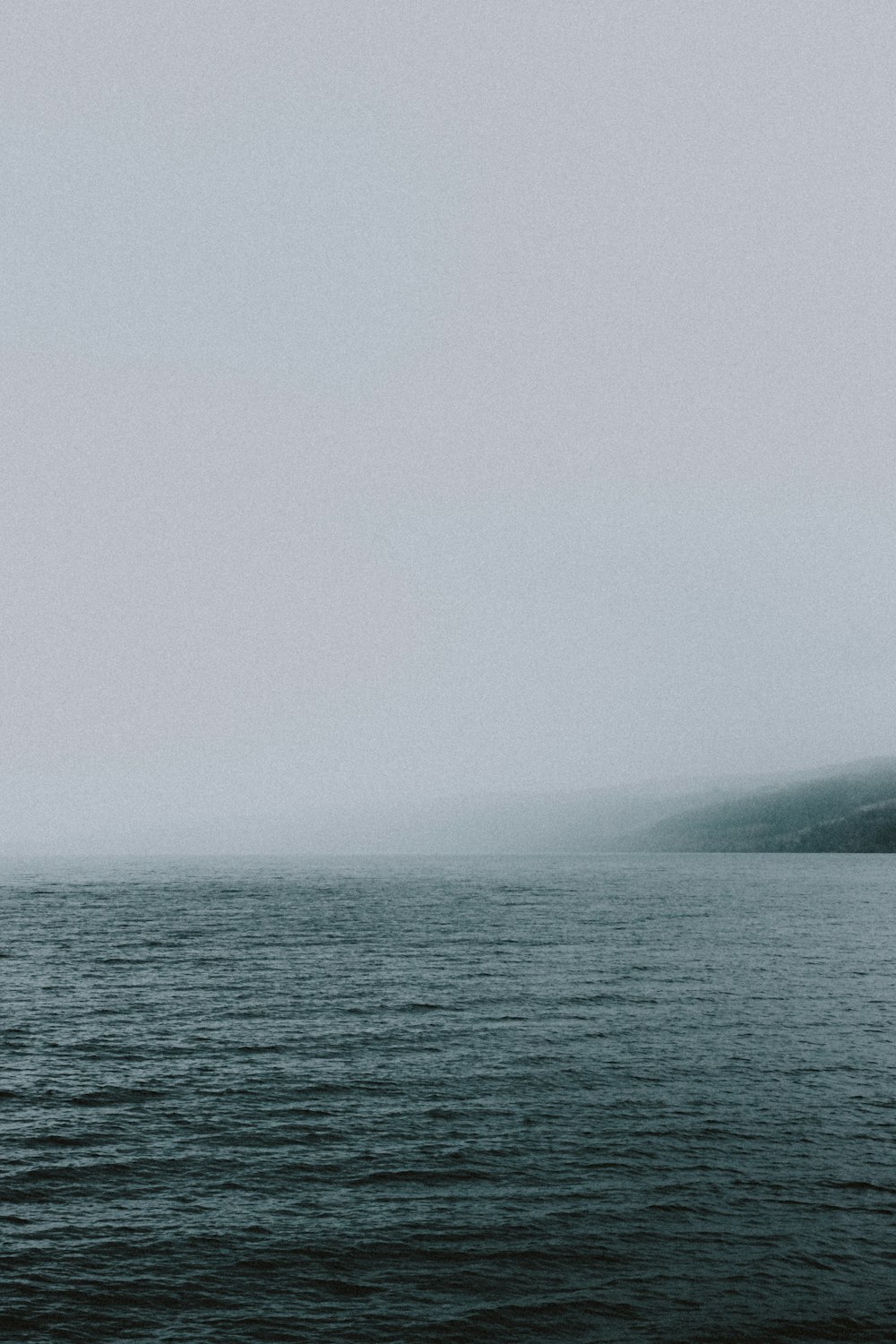 body of water near mountain during daytime