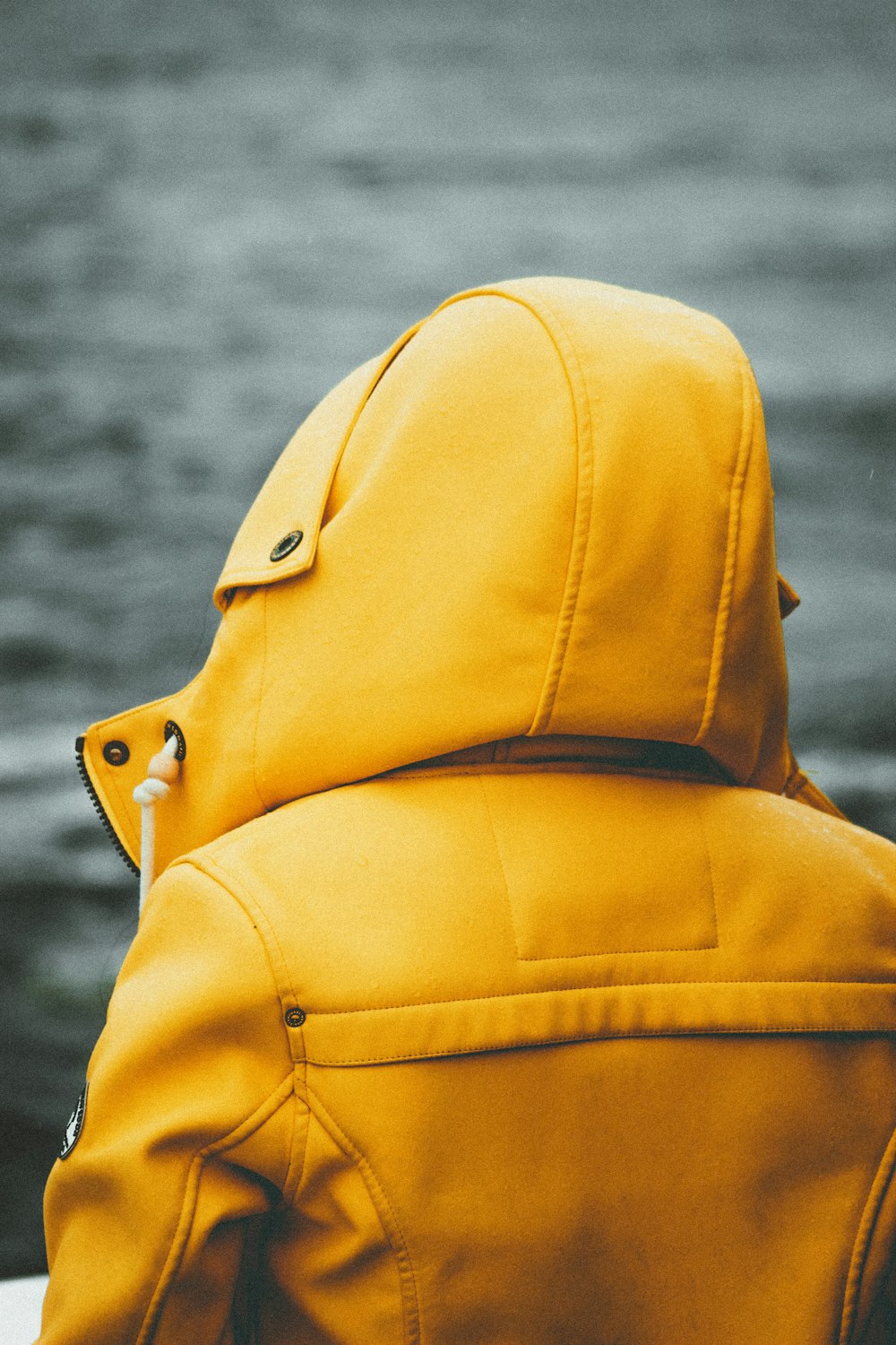 person in yellow hoodie looking at the sky