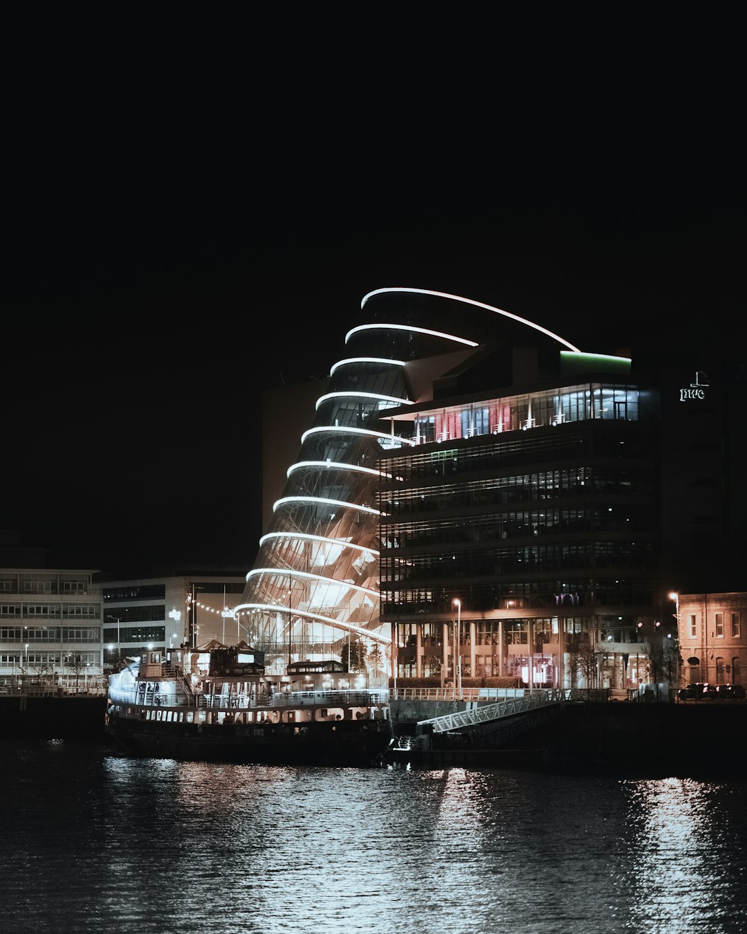 white and brown concrete building near body of water during nighttime