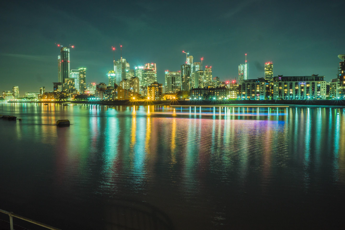 Canary Wharf skyscrapers reflecting in water after dark