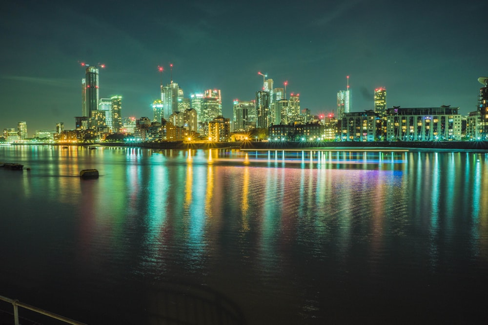 city skyline across body of water during night time