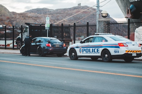 blue and white police car on road during daytime