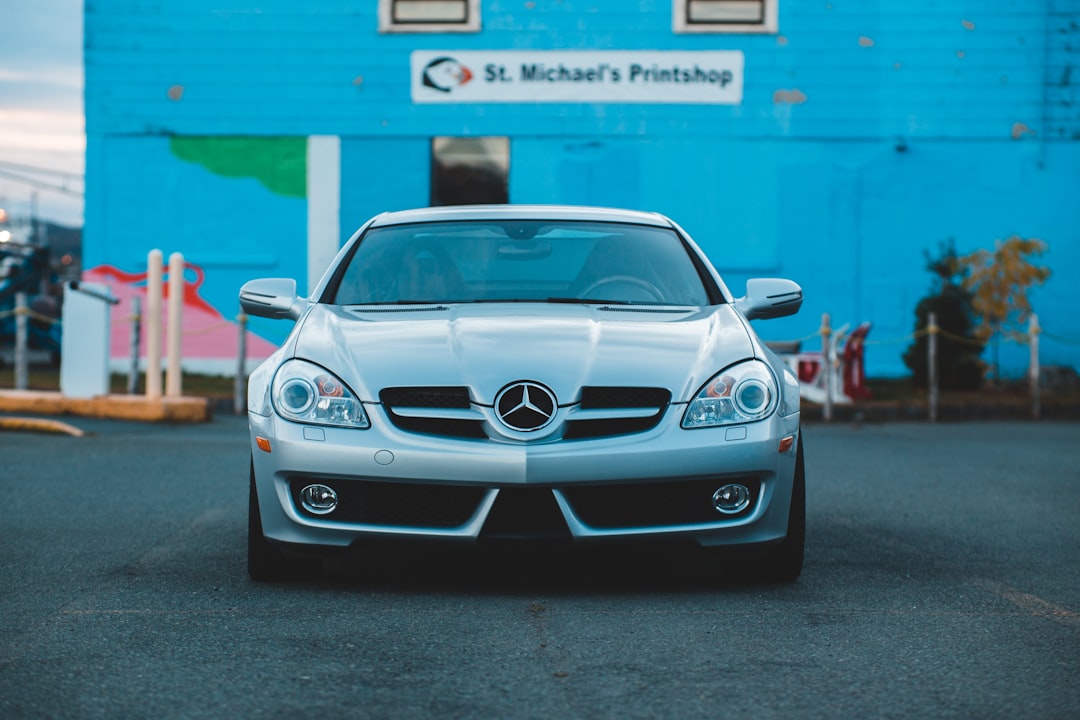 white mercedes benz coupe parked near blue wall