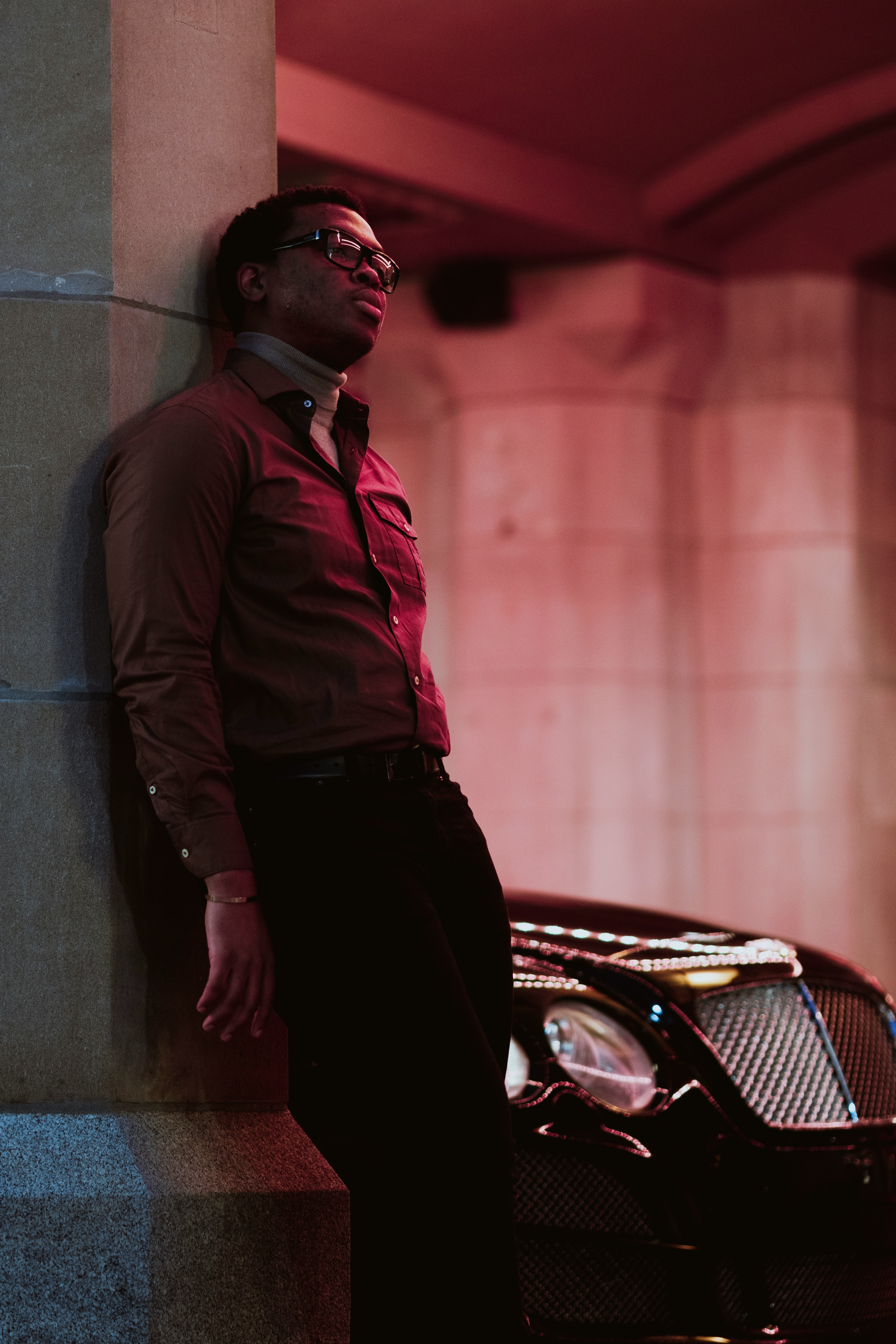 man in brown leather jacket leaning on wall