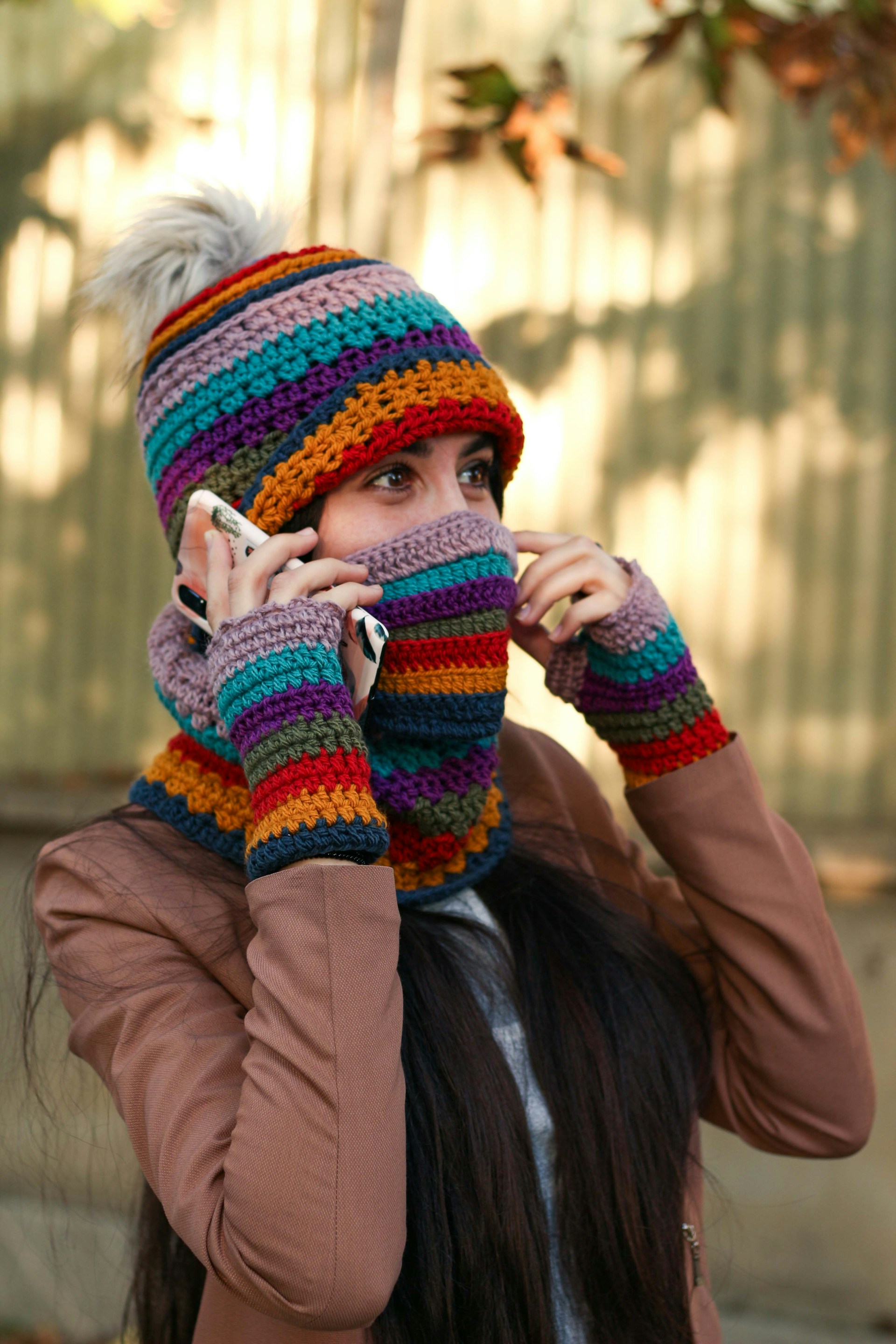 woman in brown jacket holding white ceramic mug