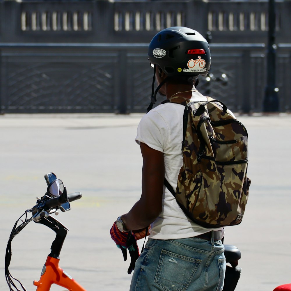 man in white t-shirt and blue denim jeans wearing black helmet riding motorcycle during daytime