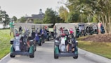 people riding on blue and white golf cart during daytime