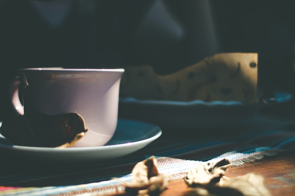 Tasse en céramique blanche sur soucoupe en céramique blanche