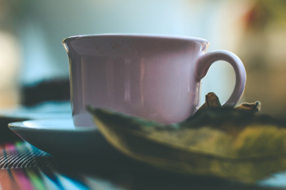 white ceramic mug on blue table