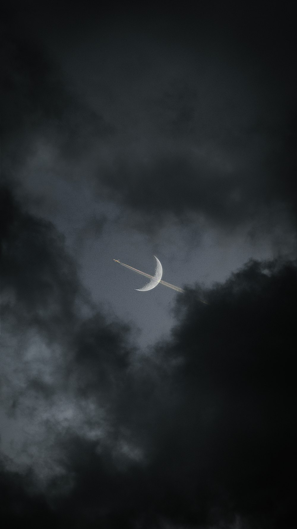 white airplane in mid air under gray clouds