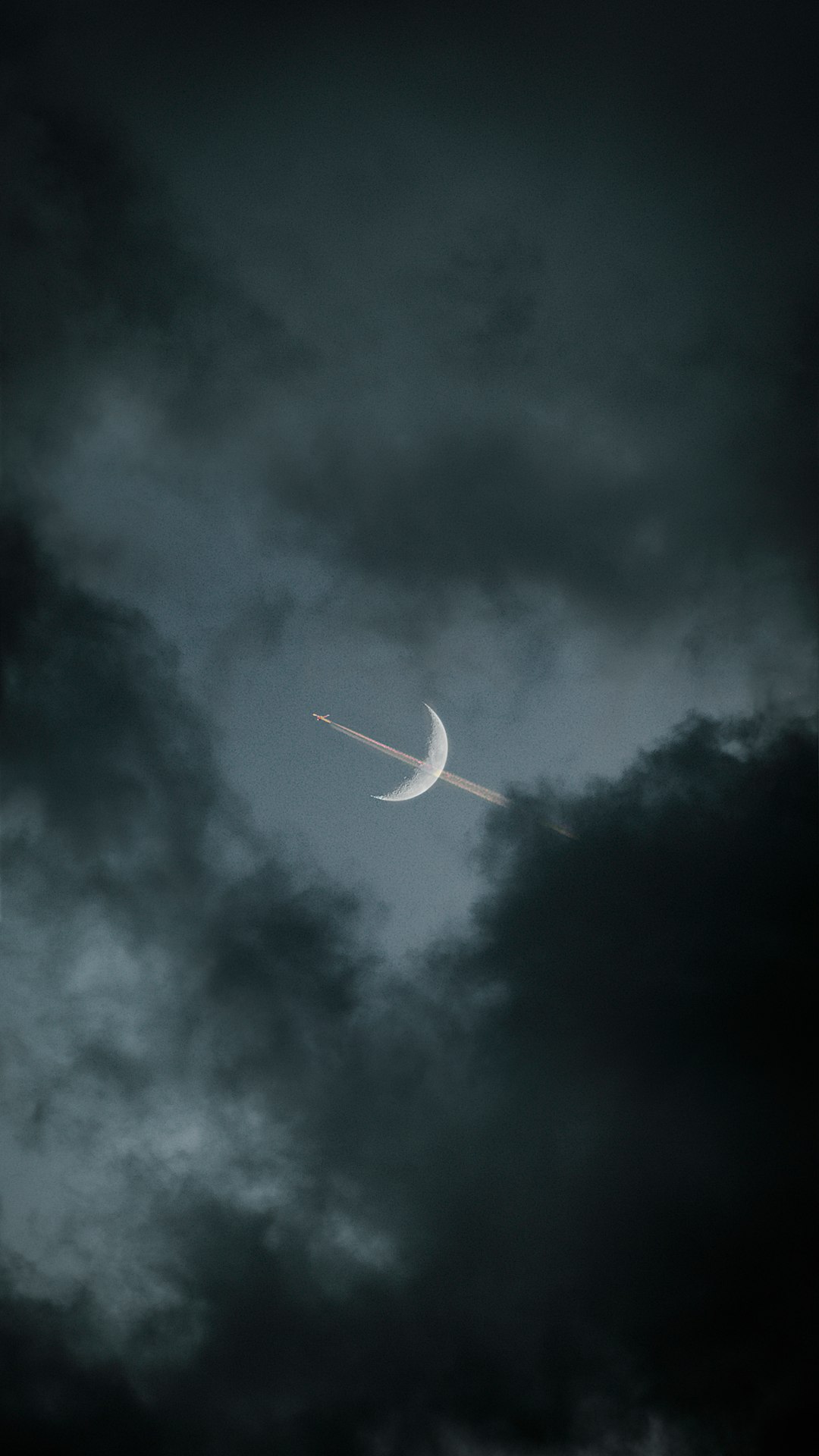 white airplane in mid air under gray clouds