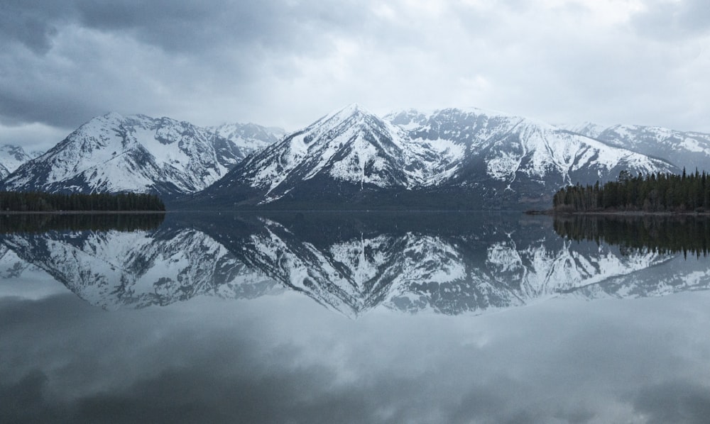 snow covered mountain near body of water during daytime