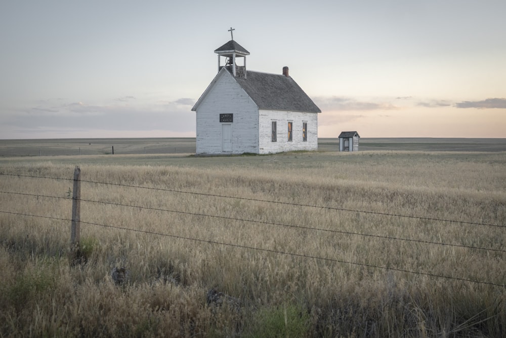 white and black house on brown field under white sky during daytime