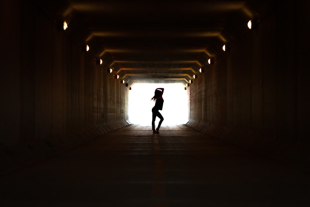 Silhouette der Person, die auf dem Tunnel geht