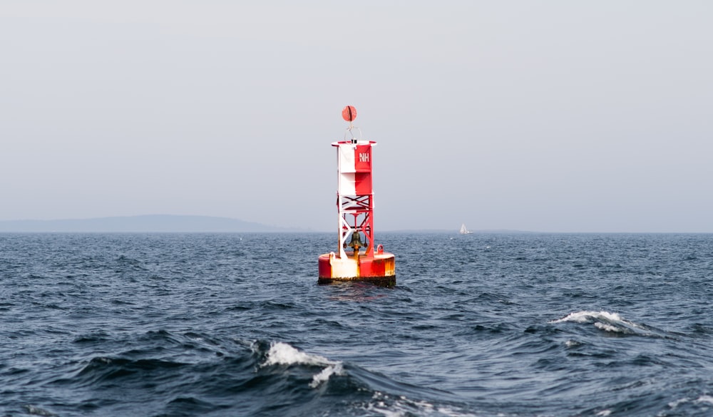 red and white striped post on sea during daytime