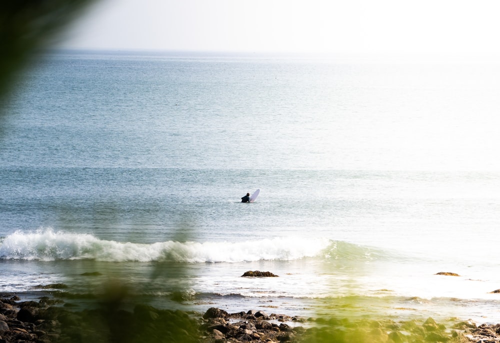 Persona surfeando sobre las olas del mar durante el día