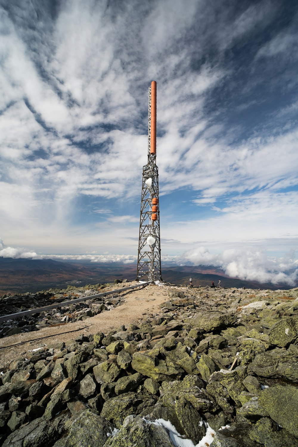 orange and white tower on brown field under blue sky