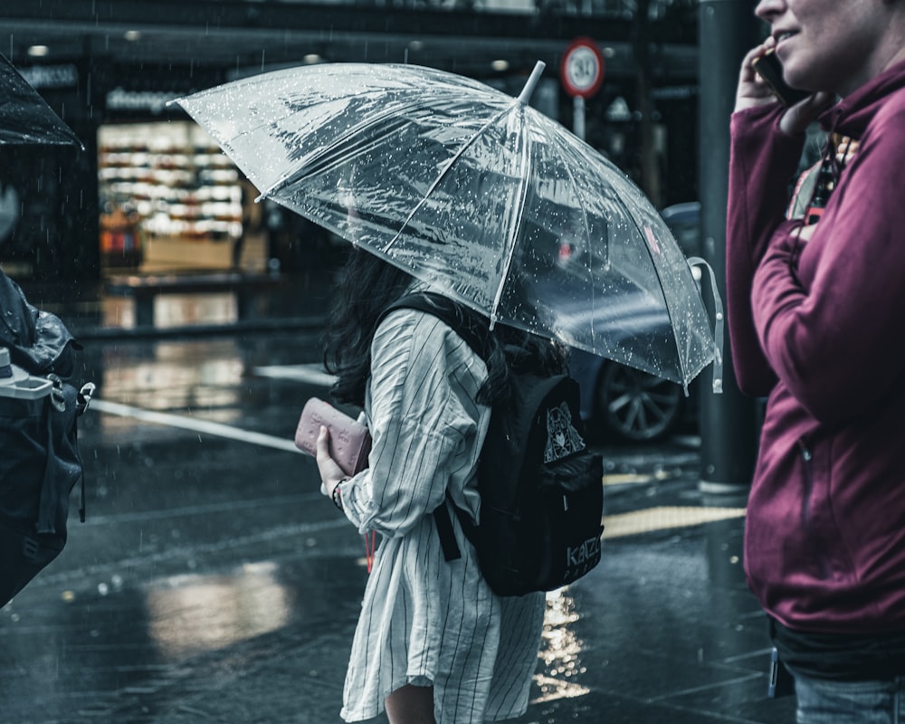 woman in pink coat holding umbrella