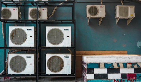 white and black box fan on brown wooden shelf