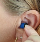 woman wearing blue stud earring