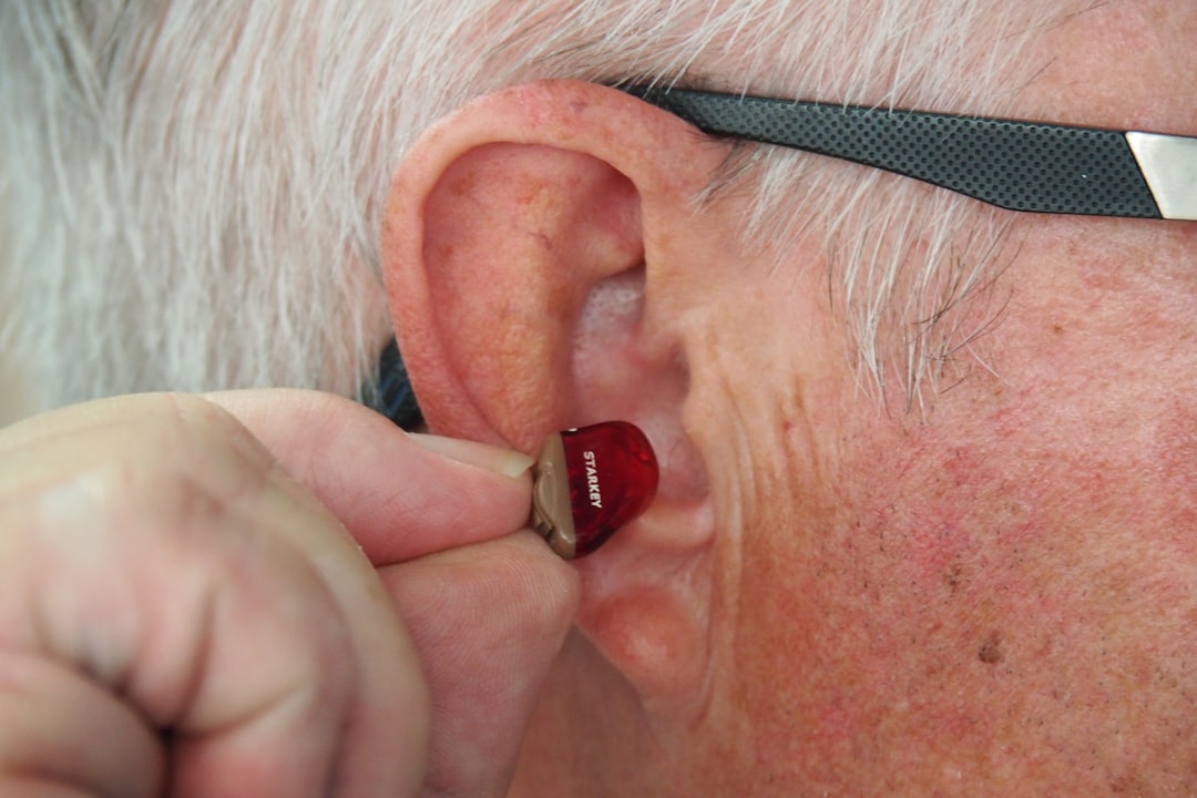 invisible hearing aid being placed in patient's ear