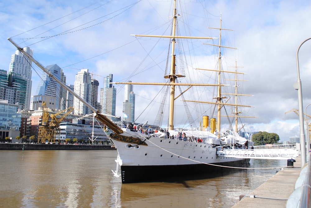 white ship on water near city buildings during daytime