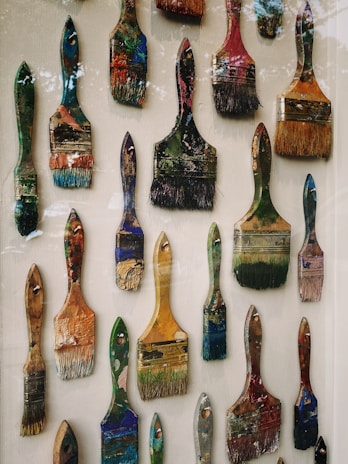 Close-up of colorful paintbrushes dipped in bright acrylic paints, arranged artistically.