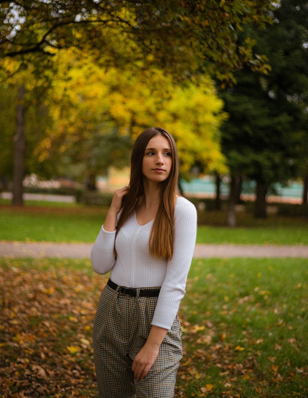 woman in white long sleeve shirt standing on green grass field during daytime