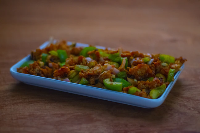 Colorful stir-fry with crisp vegetables and tender chicken, glistening under warm light.
