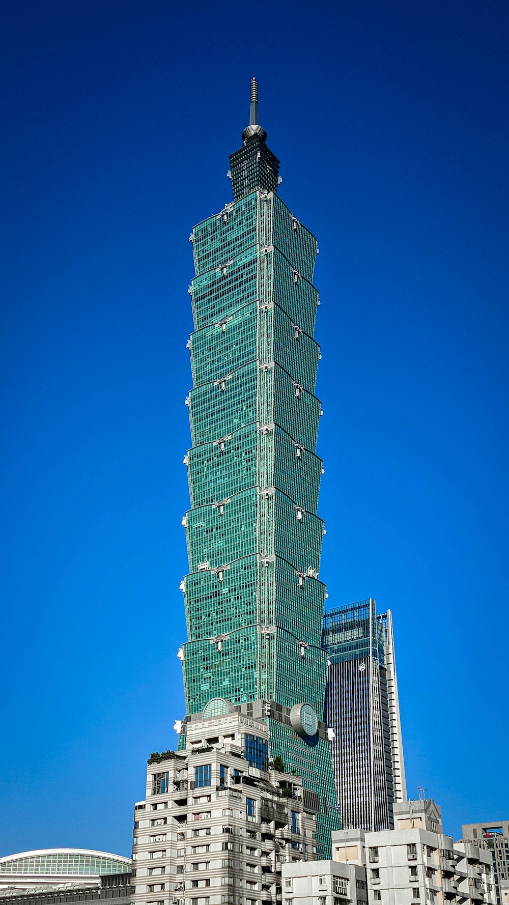 Edificio de gran altura verde y blanco bajo el cielo azul durante el día