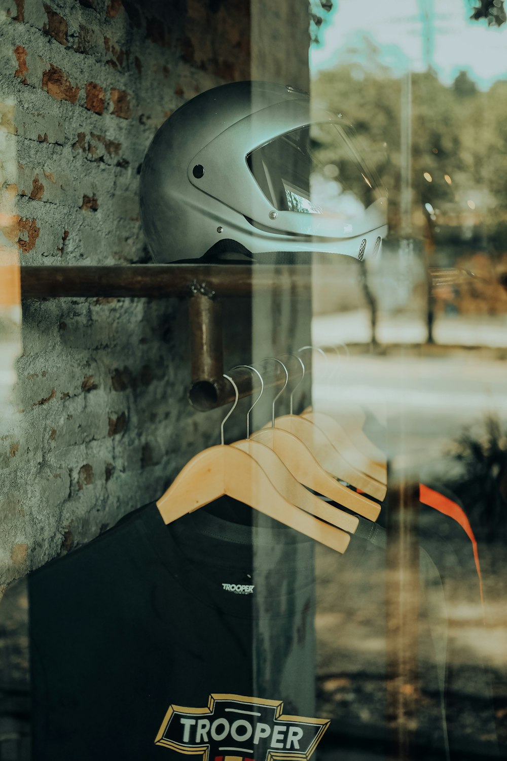 silver helmet hanging on brown wooden pole