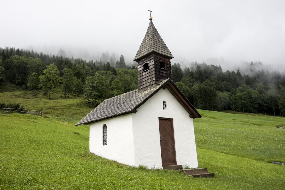 Weiße und braune Kirche auf grünem Grasfeld