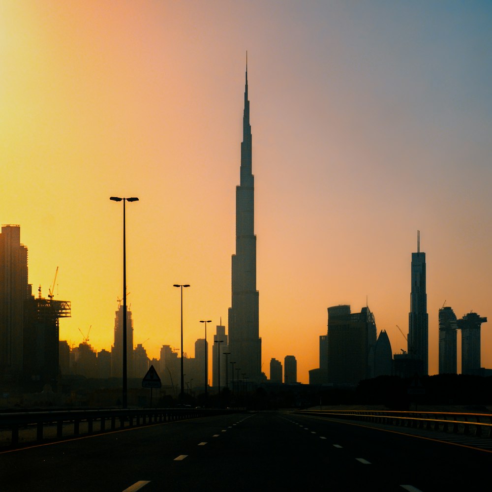 the sun is setting over a city with tall buildings