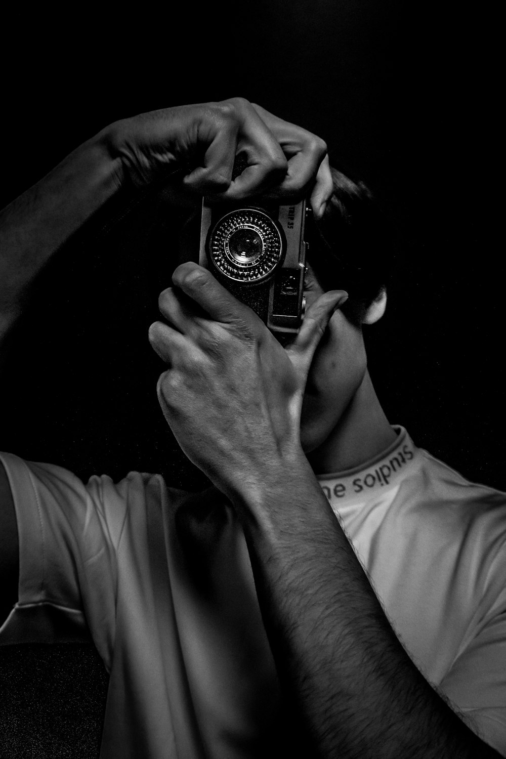 a black and white photo of a man holding a camera