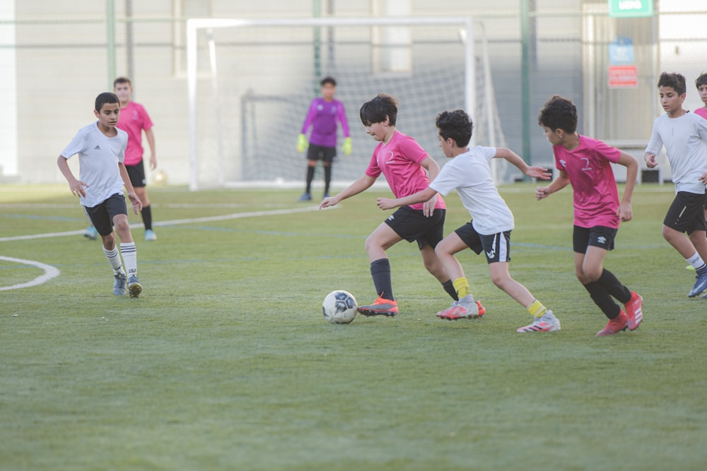 낮 동안 푸른 잔디밭에서 축구를 하는 사람들의 그룹