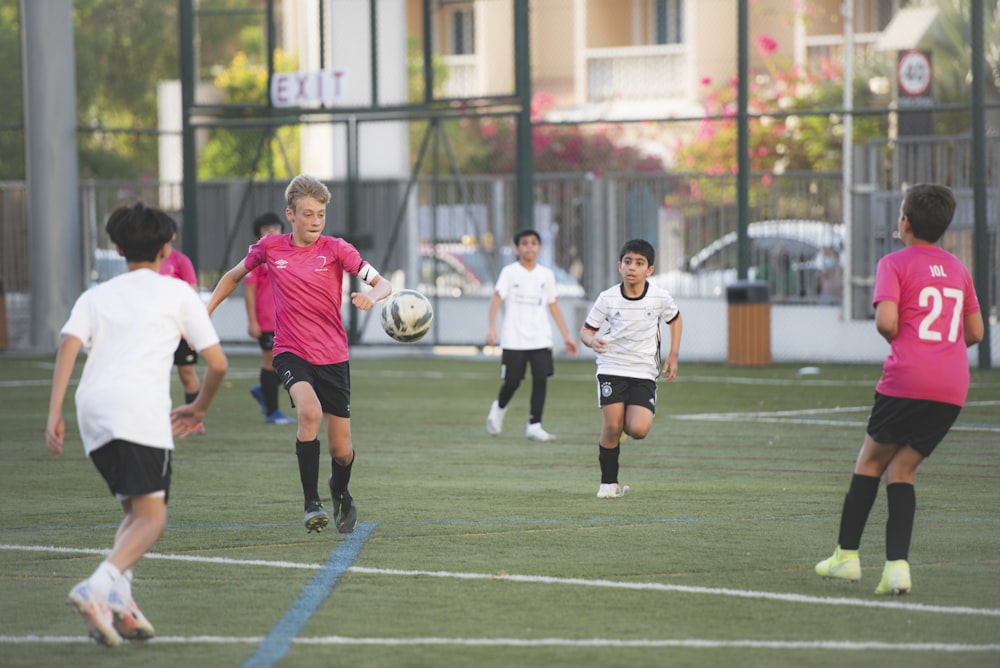 昼間に緑のフィールドでサッカーをする人々のグループ